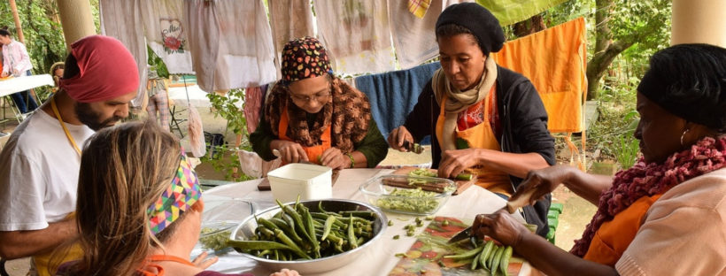 farm volunteers sit around a table preparing food